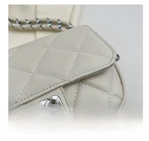 Dettaglio ravvicinato della pelle trapuntata e chiusura in metallo di borsa beige