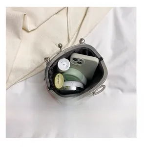 Detail presentation showing interior capacity for phone and cosmetics with bow clasp