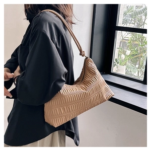 Detailed view of beige pleated shoulder bag with soft textured leather and fine ruching