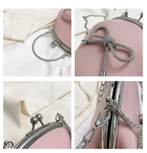 Detail of pink shell bag featuring rhinestone bowtie, metal handle and chain strap