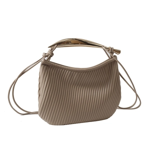 Minimalist pleated beige shoulder bag with sculptural gold metal handle for women