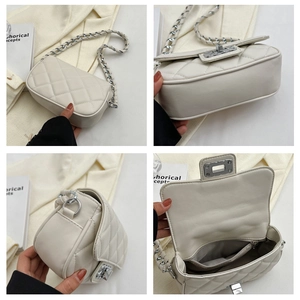 Dettaglio borsa a tracolla beige trapuntata con catena argentata e fibbia in metallo