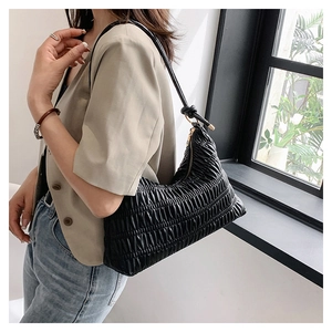 Detail view of a black pleated hobo bag showing the elegant texture and shoulder fit