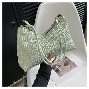 Detail of light green pleated underarm bag with double slim straps and gold hardware