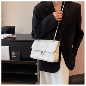 Détail du sac en cuir matelassé blanc avec chaîne argentée et fermoir rotatif rond