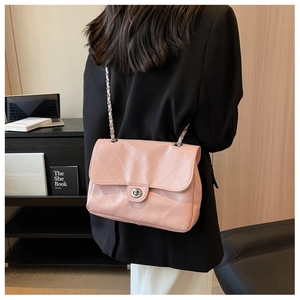Vue détaillée d'un sac bandoulière matelassé rose avec fermoir argenté et chaîne