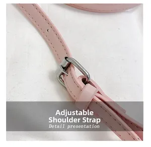 Detail of adjustable leather shoulder strap with silver buckle on pink crossbody bag