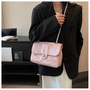 Détail du sac en cuir matelassé rose clair avec fermoir rotatif argenté et bandoulière