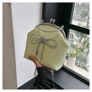 Detail of light green bow handbag with rhinestones and silver metal chain handle