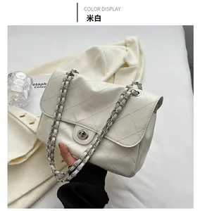 Détail du sac bandoulière matelassé crème avec chaîne argentée et fermoir rotatif