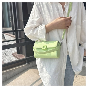 Detail of mint green leather square crossbody bag with unique metal buckle closure