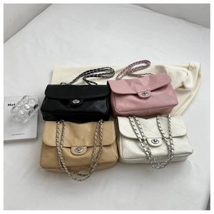 Détail de sacs à rabat matelassés noir, rose, beige et blanc avec bandoulières argent