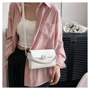 Detailed shot of white faux leather crossbody bag featuring a unique square decorative buckle