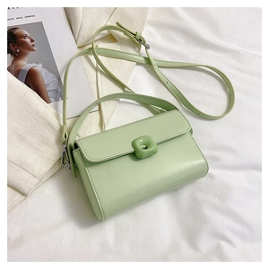 Detail of mint green square crossbody bag with textured leather and decorative buckle