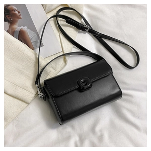 Detail of a black square shoulder bag with smooth PU leather finish on soft fabric