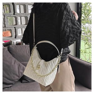 Dettaglio della borsa hobo bianca a pieghe con catena dorata e finitura trapuntata