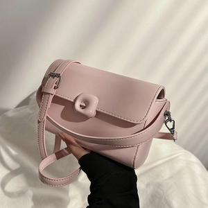 Minimalist light pink crossbody bag in matte faux leather with silver buckle closure