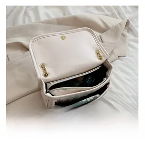 Detail show of internal compartments in white quilted chain bag for phone and makeup