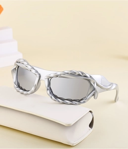 Macro view of silver Y2K sunglasses with spiral twisted metal frame and mirrored lenses