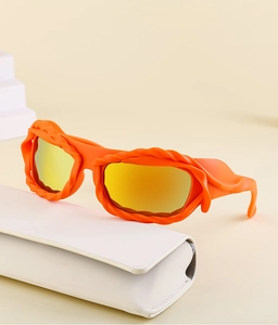 Detail of Y2K orange wavy frame sunglasses with yellow reflective lenses and a white case