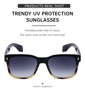 Détail de lunettes de soleil carrées vintage avec monture dégradée et flèches dorées
