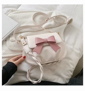 Dettaglio della borsa a tracolla in PU crema con fiocco rosa e texture plissettata fine