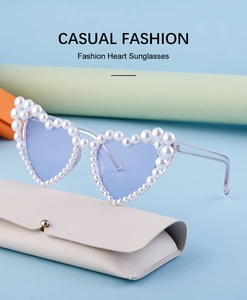 Detailaufnahme der herzförmigen Sonnenbrille mit Perlenrahmen und Bügeln