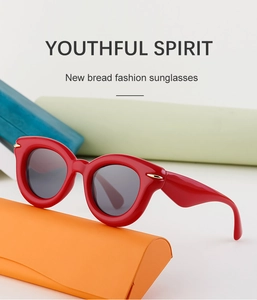 Vue détaillée de lunettes de soleil rouges rétro avec accents dorés sur étui orange