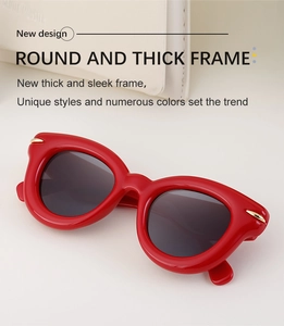 Détail de lunettes de soleil œil-de-chat rouges avec monture épaisse et détails dorés