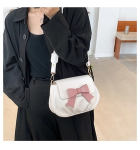 Dettaglio della borsa a tracolla bianca in PU con fiocco rosa e fibbie dorate