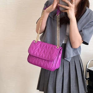 Purple quilted shoulder bag with gold chain strap shown on model with leaf-stitch detail