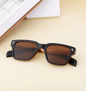 Gros plan sur les lunettes de soleil carrées avec monture noire et logo T métallique