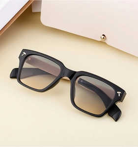 Détail de lunettes de soleil carrées noires avec verres dégradés et insert en métal en T