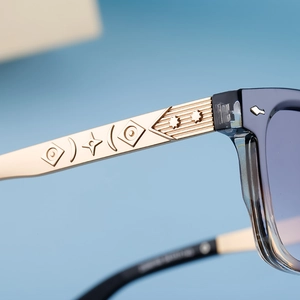 Detail of vintage square sunglasses with gold metal temples and geometric relief patterns