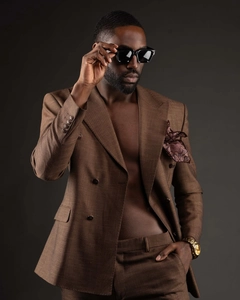 Close-up of trendy black square sunglasses worn with a premium brown checkered suit