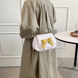Borsa a tracolla crema con fiocco giallo vibrante e dettagli in metallo dorato lucido