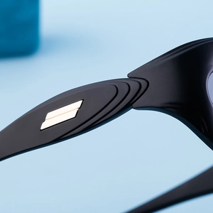 Detail of matte black Y2K sunglasses with dual gold parallel metal temple accents
