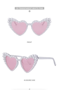 Detail einer herzförmigen Sonnenbrille mit Glitzerrahmen und Perlenverzierung