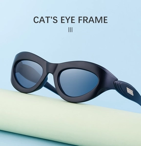 Detail of black cat-eye sunglasses with silver metal hinges on a pastel pedestal