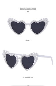 Front- und Seitenansicht der Herz-Sonnenbrille mit weißem Rahmen und Perlenrand