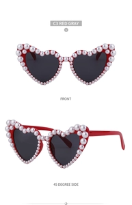 Detailansicht der herzförmigen Sonnenbrille mit rotem Rahmen und Perlenbesatz