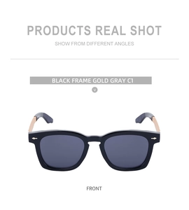 Close-up of square black vintage sunglasses featuring gold metal temples and gray lenses