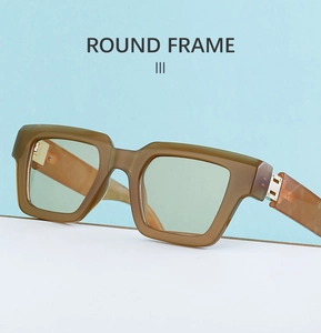 Détail de lunettes de soleil carrées vert olive avec charnières métalliques sur fond neutre