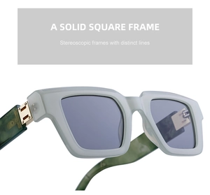 Détail de lunettes de soleil carrées avec monture vert olive et branches marbrées