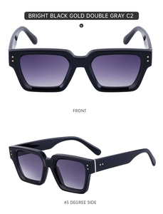 Detail view of bright black square sunglasses with gold metal dots and gradient lenses