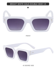 Detail view of white square sunglasses with dark gray lenses and golden hinge accents