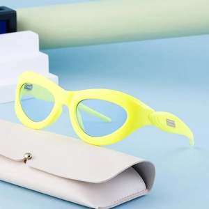Y2K cat-eye sunglasses with yellow frame and blue lenses on minimalist geometric stand