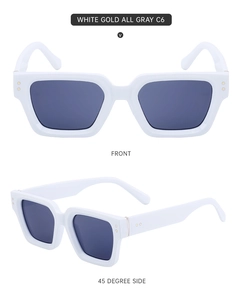 Detalle de gafas de sol cuadradas blancas con acentos dorados y cristales grises