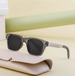 Detail of square polarized sunglasses featuring silver arrow rivets and carved metal temples