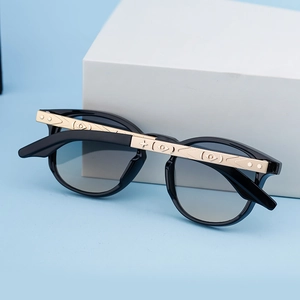 Detail of gold metal temples with geometric relief patterns on black square sunglasses